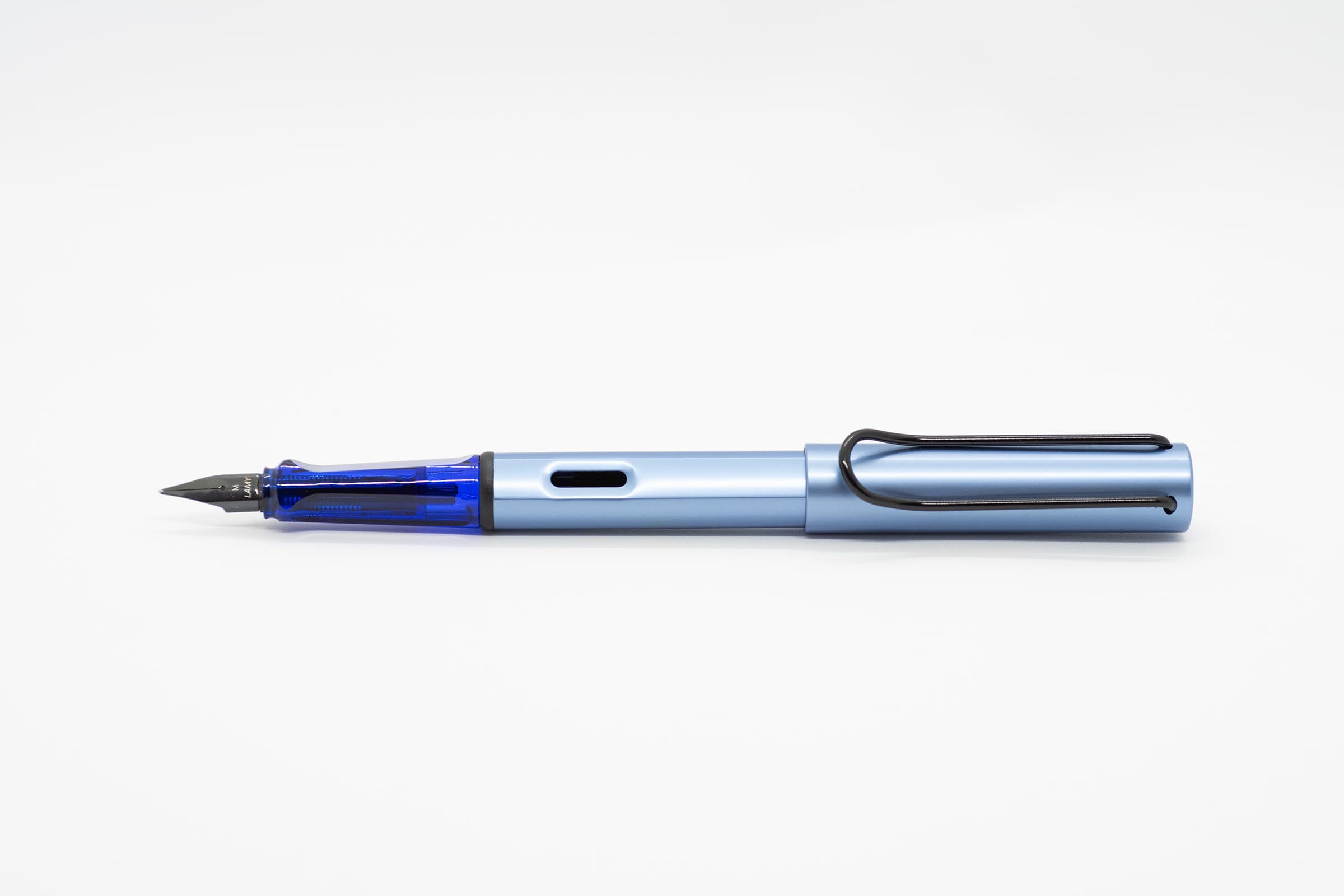 白い背景に横向きに置いたLAMY AL-star アクアティック。淡いブルーの軸とキャップ、透明ブルーのグリップと黒いニブ、クリップ