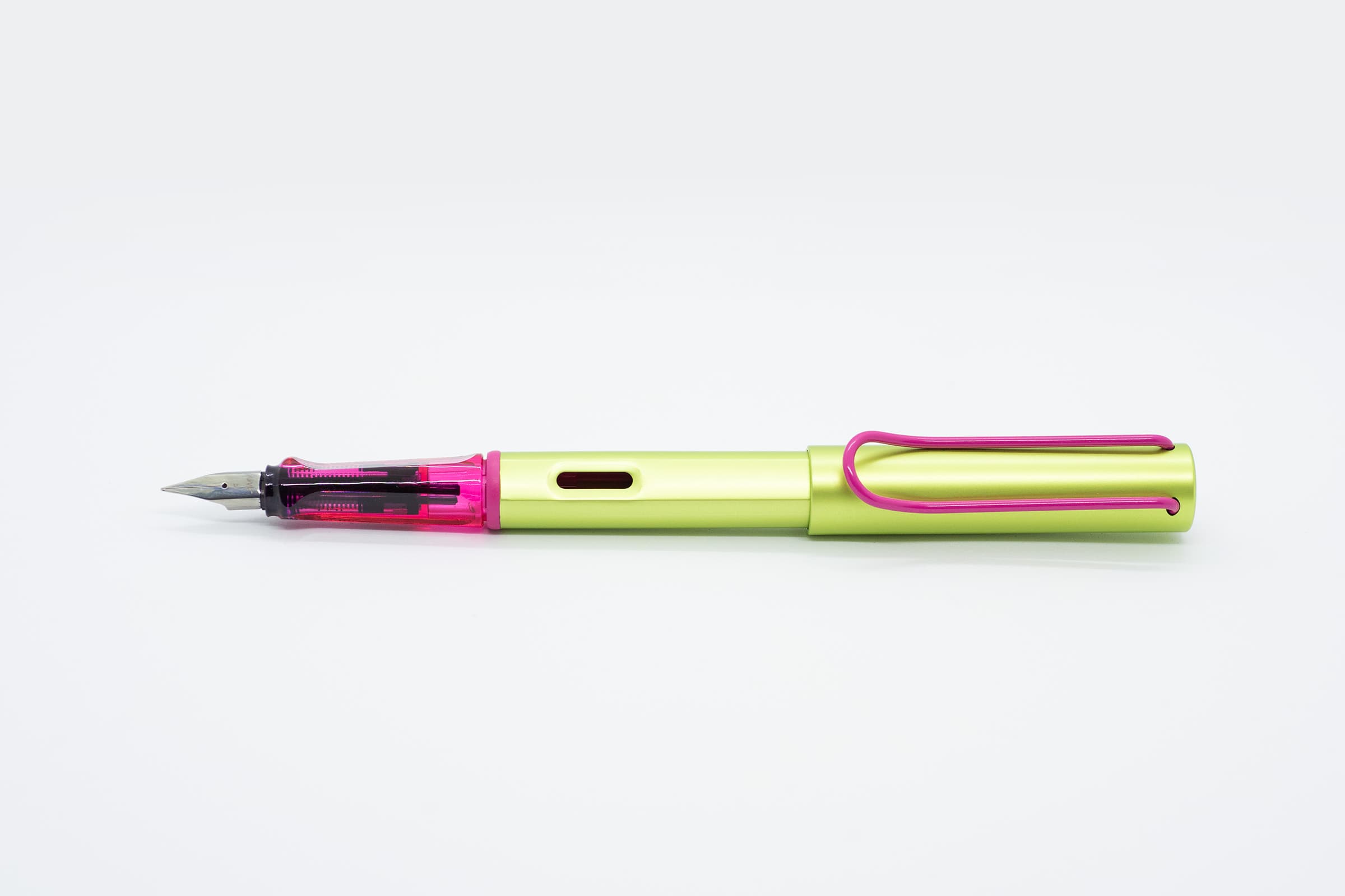 白い背景に横向きに置いたLAMY AL-star ディスコ。蛍光イエローグリーンの軸とキャップ、透明ピンクのグリップとピンクのクリップ
