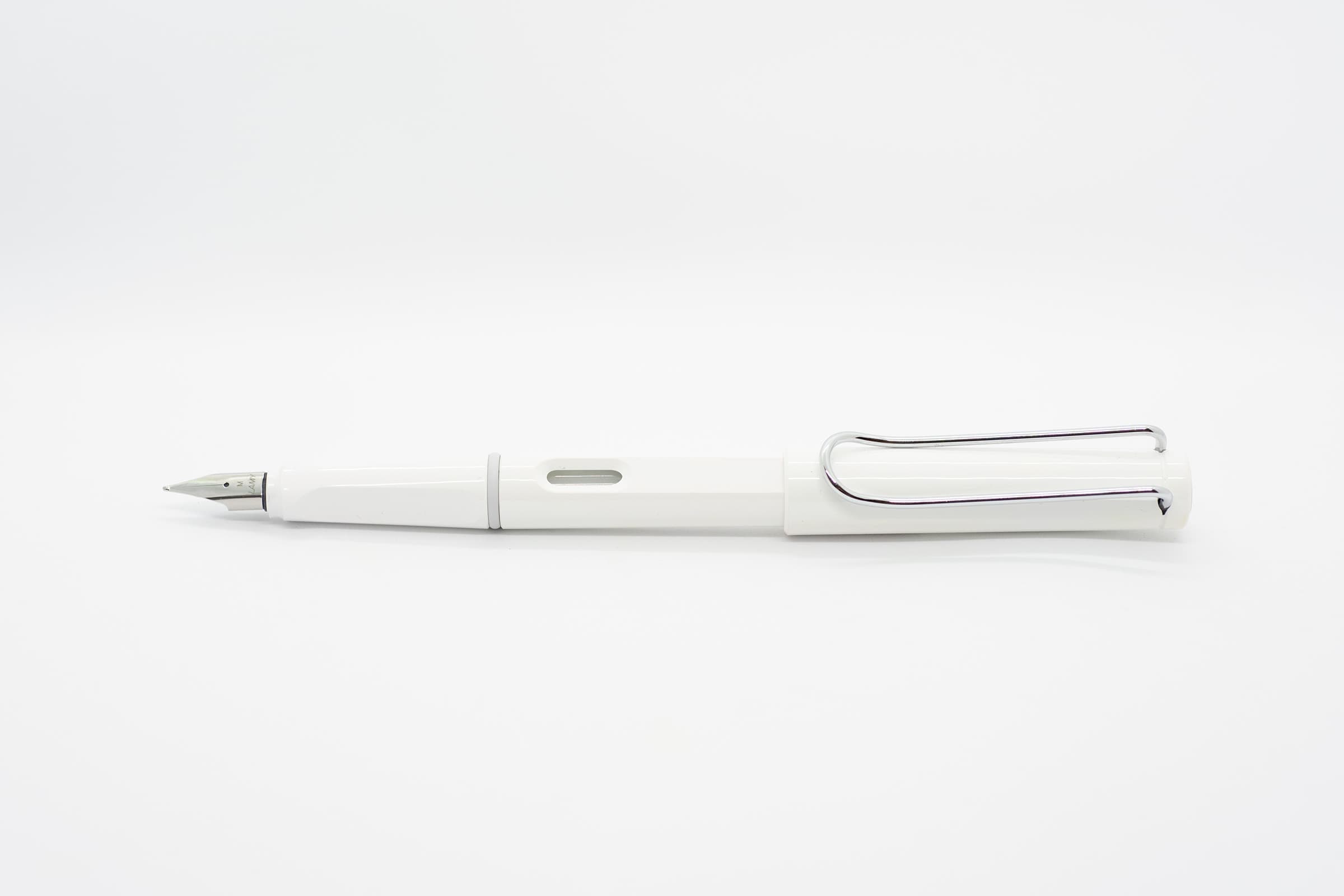 白い背景に横向きに置いたLAMY Safari ホワイト。光沢のある白い軸とキャップ、シルバーのニブとクリップ