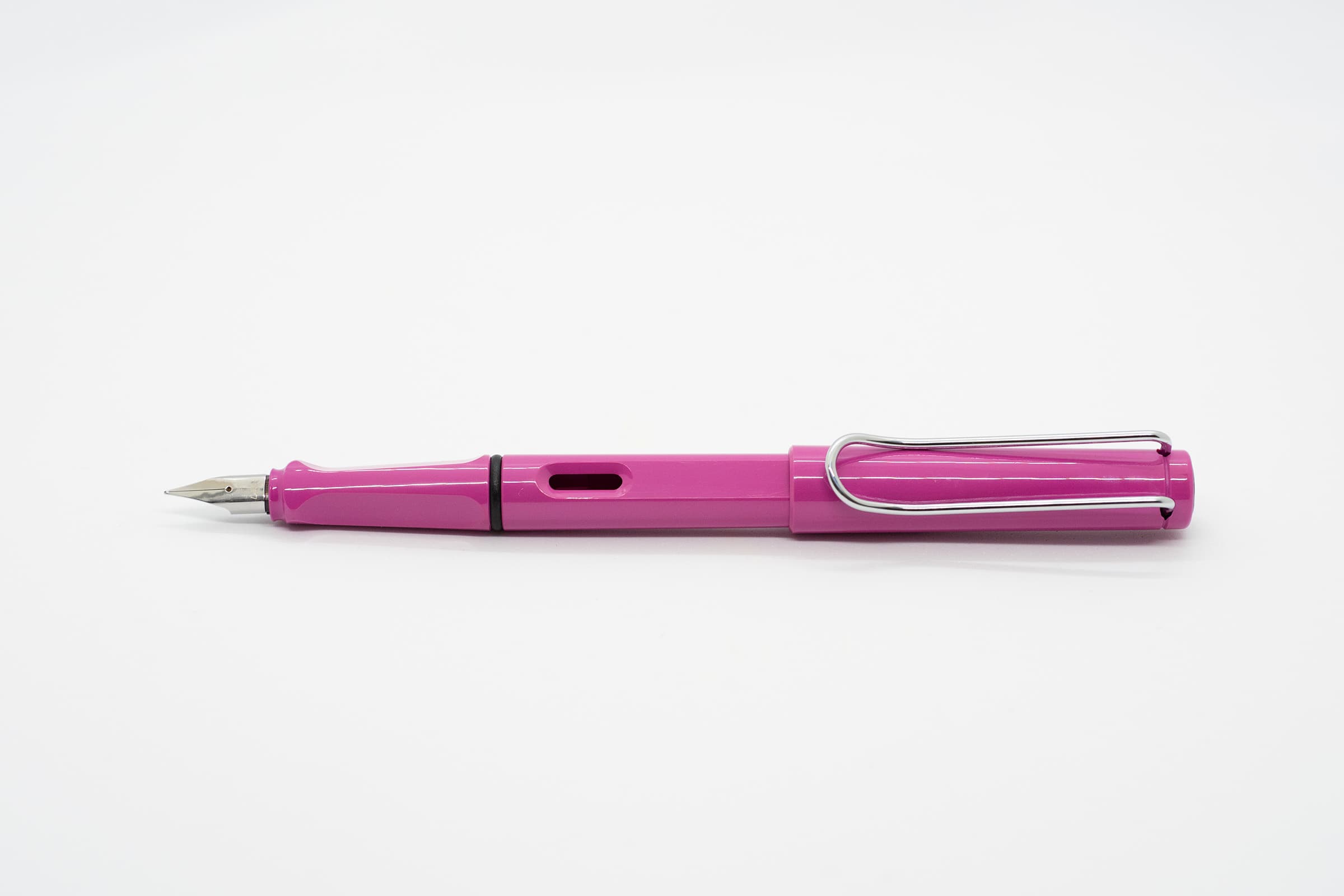 白い背景に横向きに置いたLAMY Safari ピンク。光沢のあるピンクの軸とキャップ、シルバーのニブとクリップ
