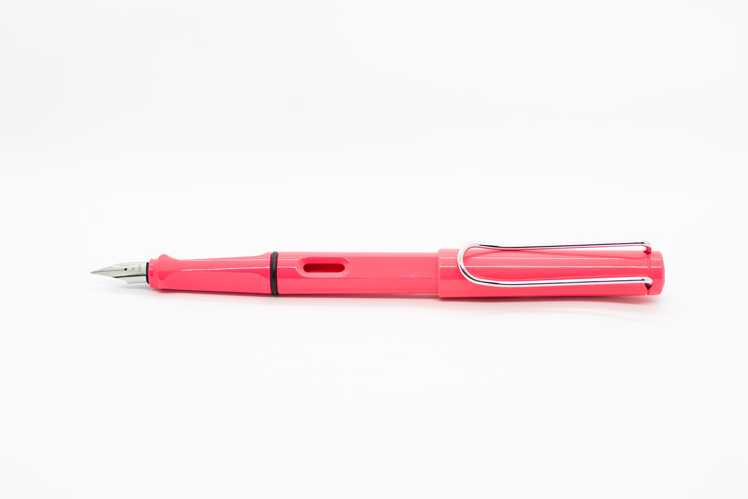 白い背景に横向きに置いたLAMY Safari ネオンコーラル。鮮やかなコーラル色の軸とキャップ、シルバーのニブとクリップ