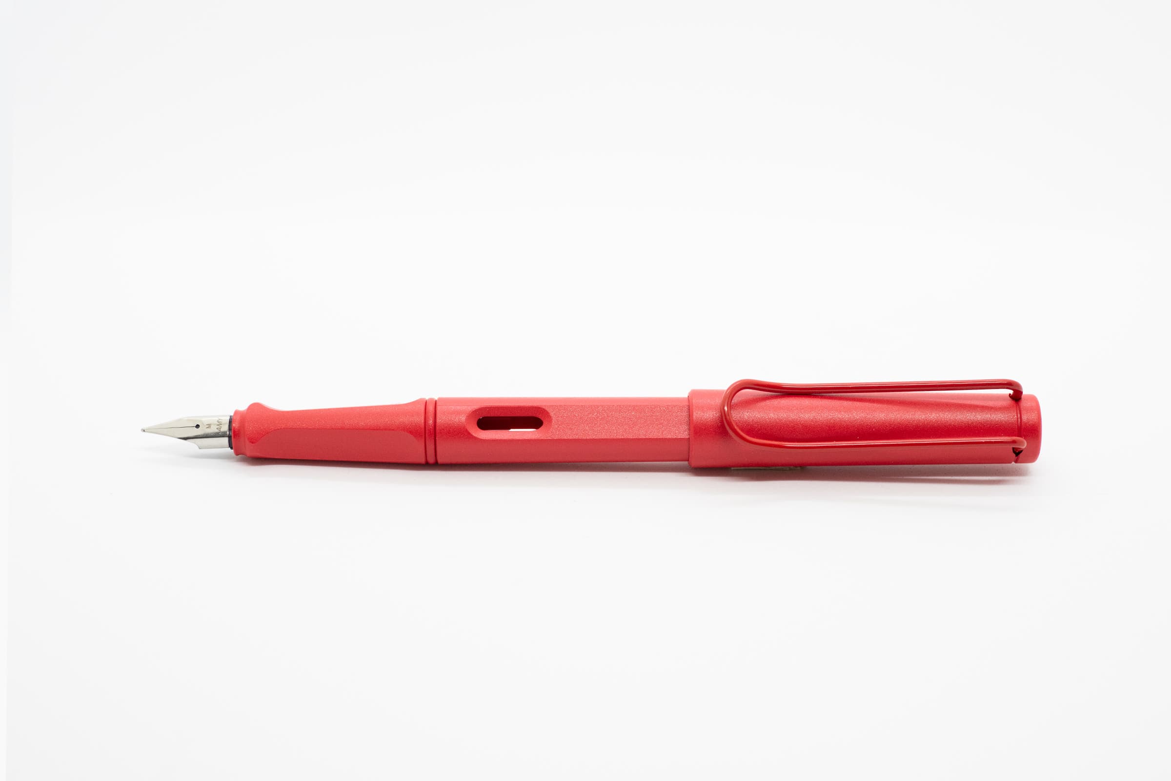 白い背景に横向きに置いたLAMY Safari ストロベリー。赤い軸とキャップ、シルバーのニブ