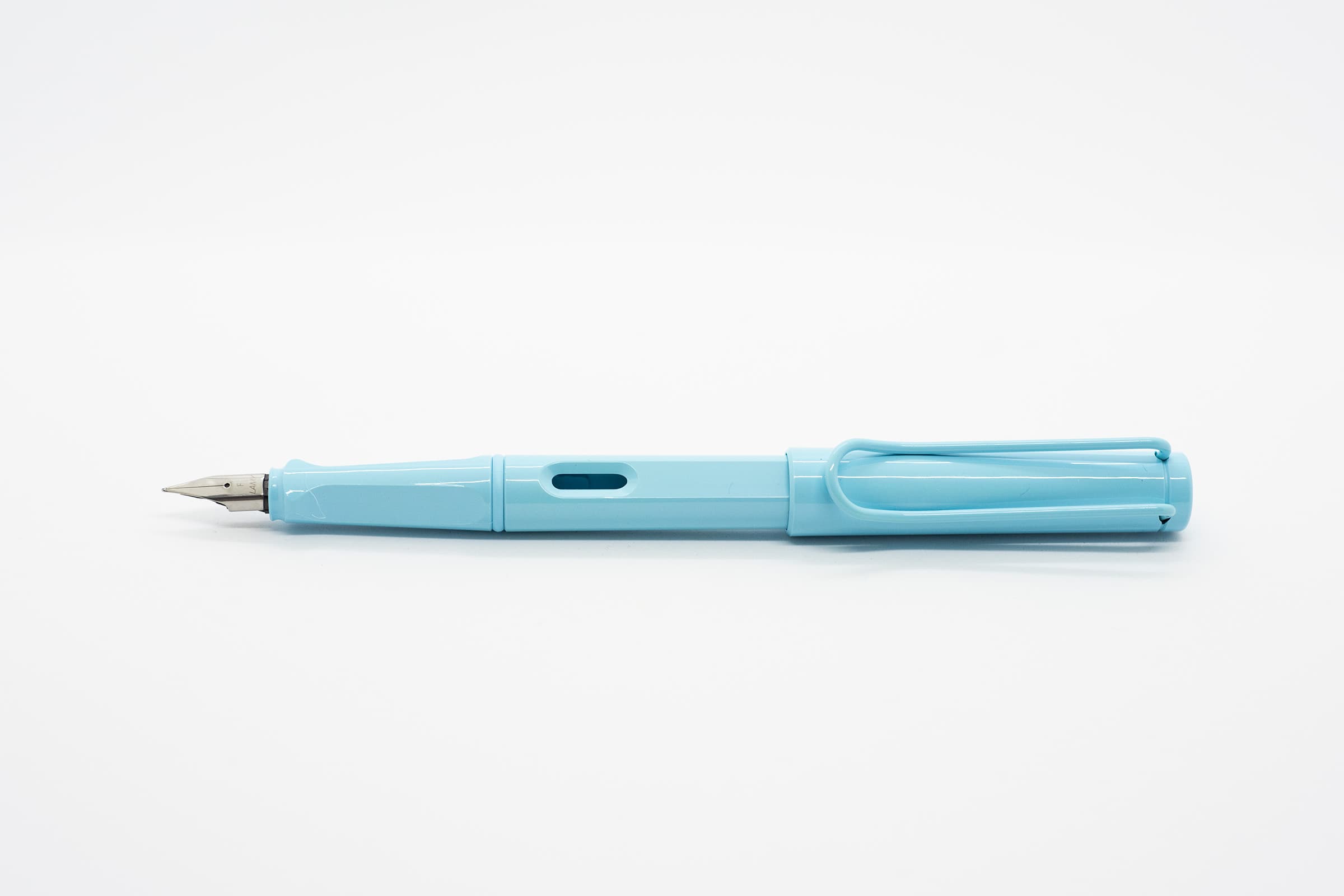 白い背景に横向きに置いたLAMY Safari アクアスカイ。明るいアクアブルーの軸とキャップ、シルバーのニブ