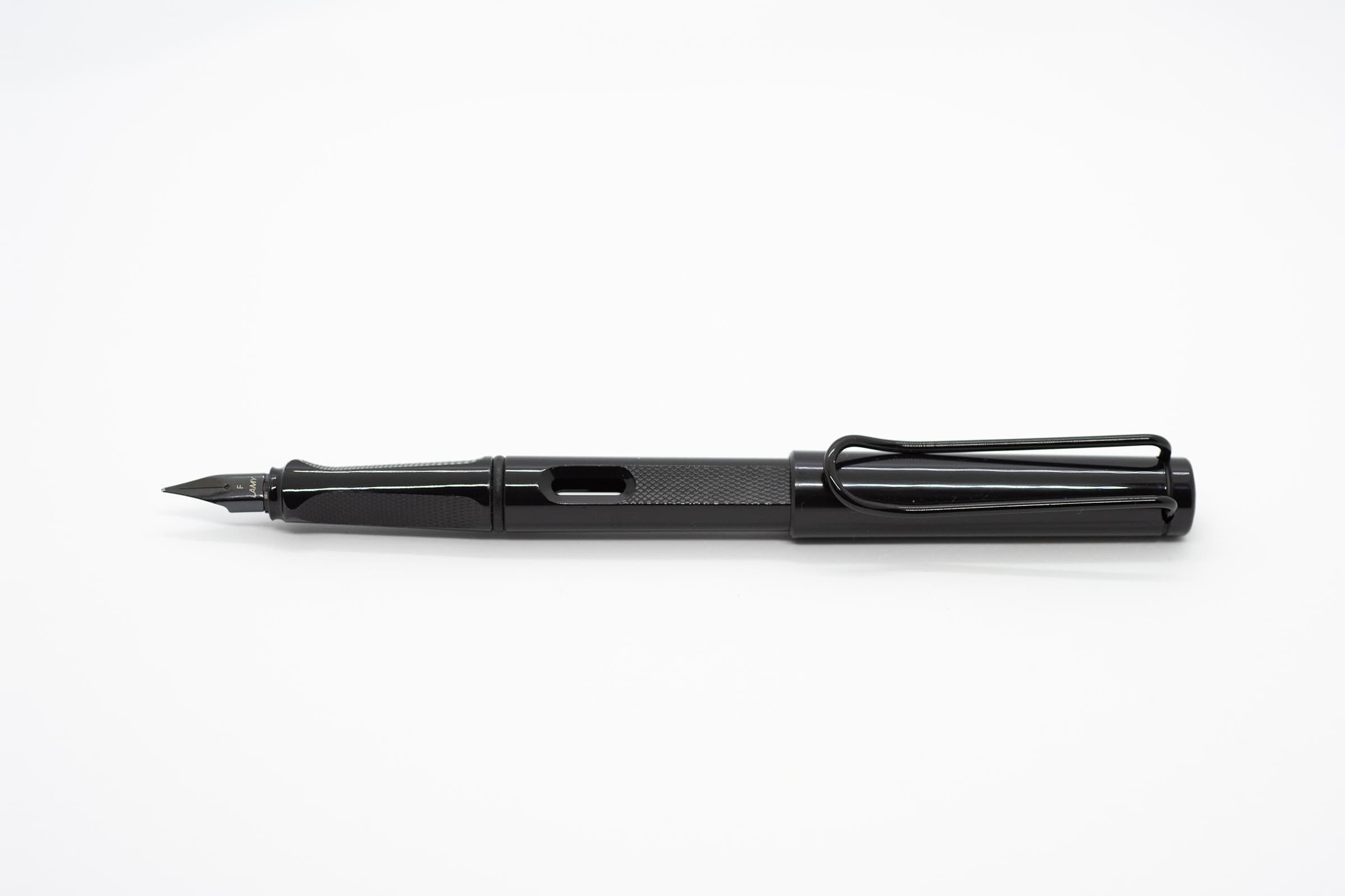 白い背景に横向きに置いたLAMY Safari メテオライト。光沢のある黒い軸とキャップ、凹凸模様のある軸とグリップ、黒いニブとクリップ
